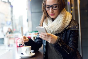 Portrait of beautiful girl using her mobile phone in cafe.